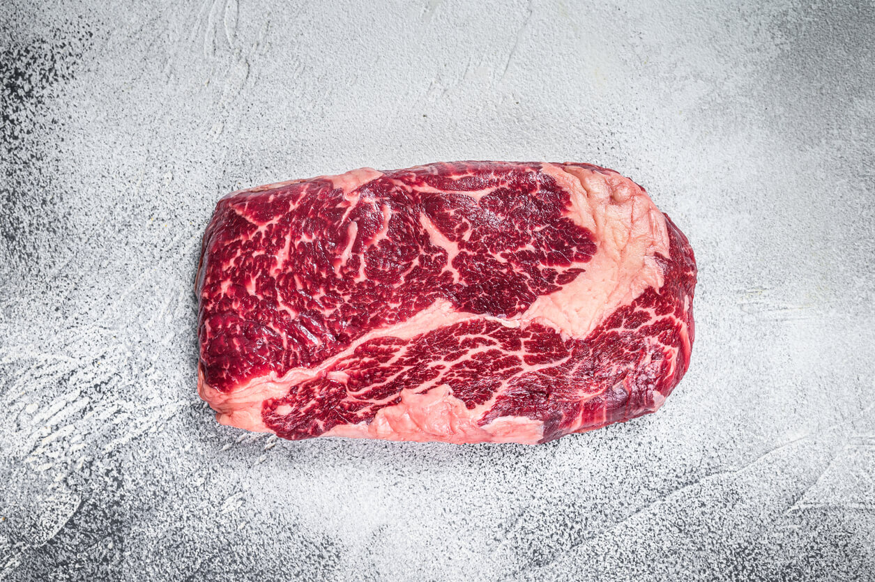 The Truth About Ribeye Steak's Price: 3+ Reasons Explained 1 Raw rib eye beef meat steak on a table prepared for the gril. White background. Top view