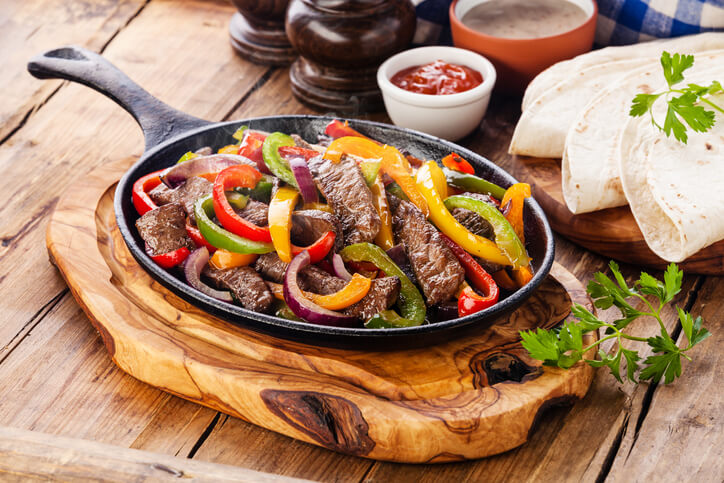 Steak for Fajitas: 3+ Types You Must Try - A Guide for Foodies 1 Beef Fajitas with colorful bell peppers in pan and tortilla bread and sauces