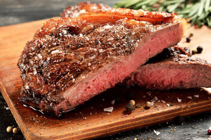 Prime Black Angus New York strip steak. Rare degree of steak doneness.