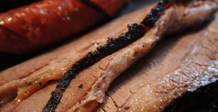 A closeup view of wagyu beef brisket and sausage at a BBQ restaurant in Texas