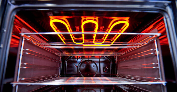 Empty hot oven with a flaming grill close-up.
