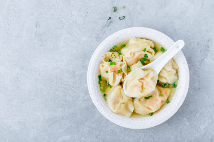 Wonton soup bowl. Shrimp or pork wonton soup with green onion, top view, copy space