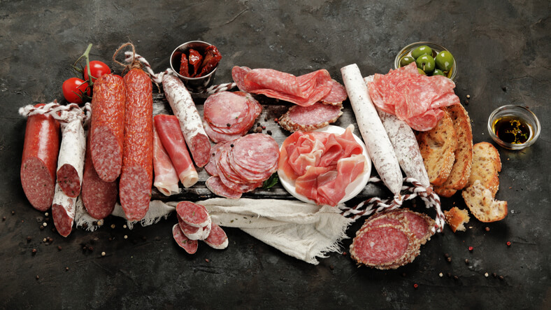 7+ Different Cuts of Deli Meat You Need to Try Now 1 Sasusages assortment on dark background. Meat product made of finely chopped and seasoned meat.