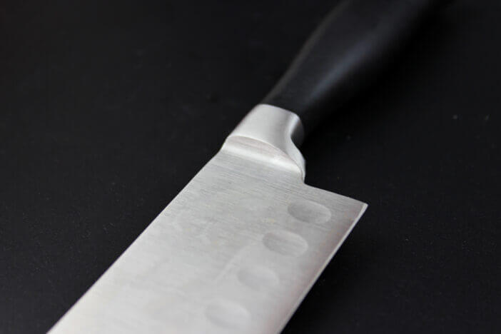 Kitchen utensils on black background. Cutting sharp knife.