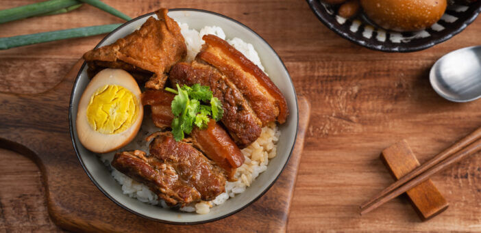 Braised pork belly, close up of stewed pork chop over cooked rice in Taiwan. Taiwanese famous traditional street food delicacy.