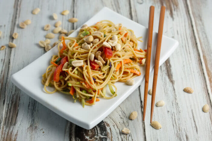 11+ Delicious Sides to Enjoy with Skirt Steak 2 A cold asian noodle salad on a white plate with chopsticks.