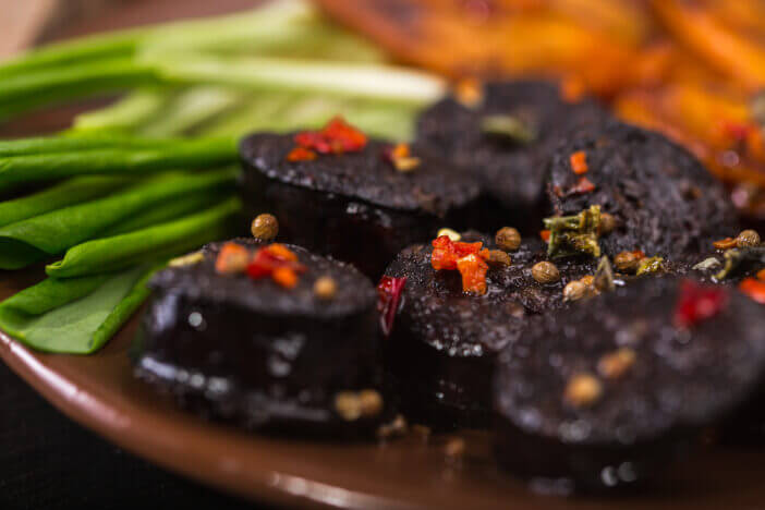 macro image of black pudding sausage with spices on a cutting board