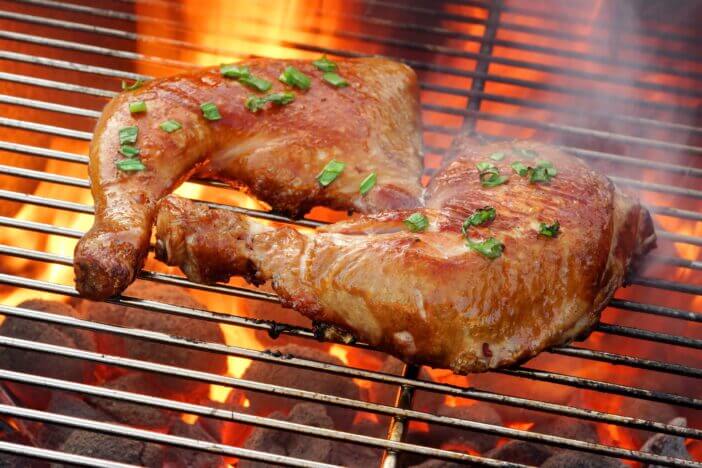 10+ Things to Know About Chicken Leg Quarters 3 Close-up Overhead View On Two Tasty Roast And Smoked Chicken Quarters On The Hot Flaming BBQ Grill In The Background