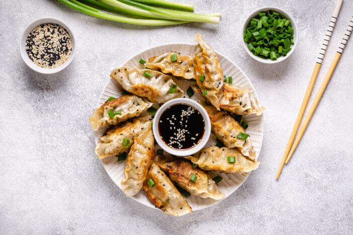 Fried dumplings gyoza with soy sauce, and chopsticks, top view.
