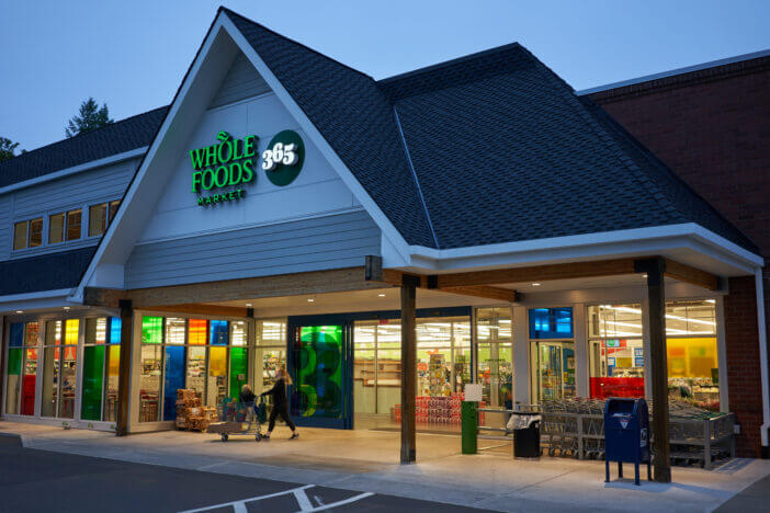 Lake Oswego, Oregon, USA - Sep 23, 2019: A shopper walking out of a Whole Foods Market 365 Store in Lake Oswego, a southern suburb within the Portland metro area in the evening.