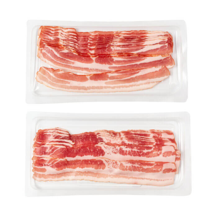 Raw smoked bacon in plastic pack isolated. Streaky brisket slices on tray, fresh thin sliced bacon on white background