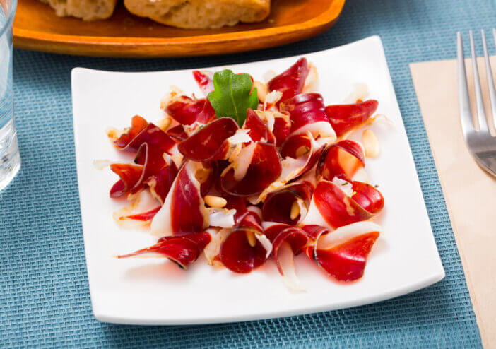 Tasty Spanish snack â duck jamon served with aragula