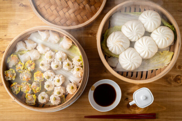 chinese steamed buns and shumai in bamboo steamer