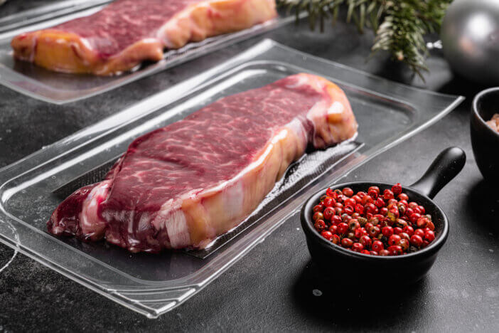 11 Special Occasion Meat Gifts For This Holiday Season 5 Raw steak with Christmas tree decorations set, on black dark stone table background
