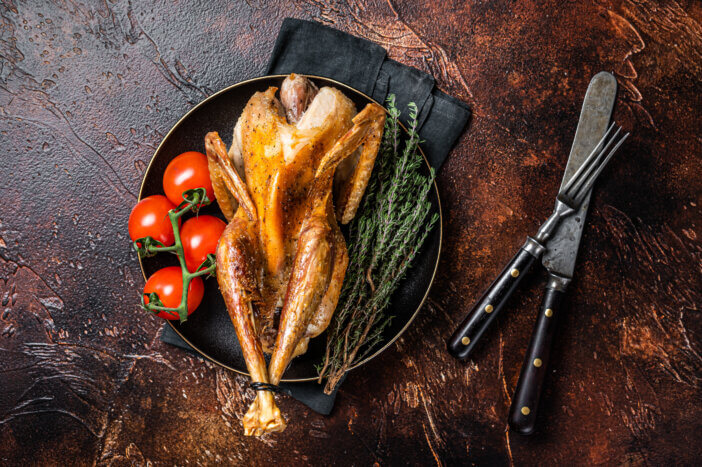 9 Gourmet Meats For Cooking For Home Chefs & Food Bloggers 9 Roast guinea fowl with herbs and spices, cooked game bird. Dark background. Top view.