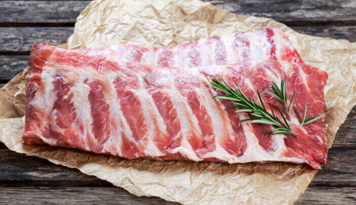 6 Grill Ready Meat Cuts For Grilling Enthusiasts 3 Raw Pork ribs with a rosemary. on crumpled paper.