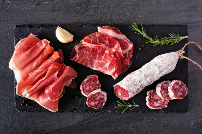 11 Premium Meat Gift Options For This Holiday Season 2 Meat appetizer platter with sausage, and Italian cold cuts. Above view on a slate serving board.
