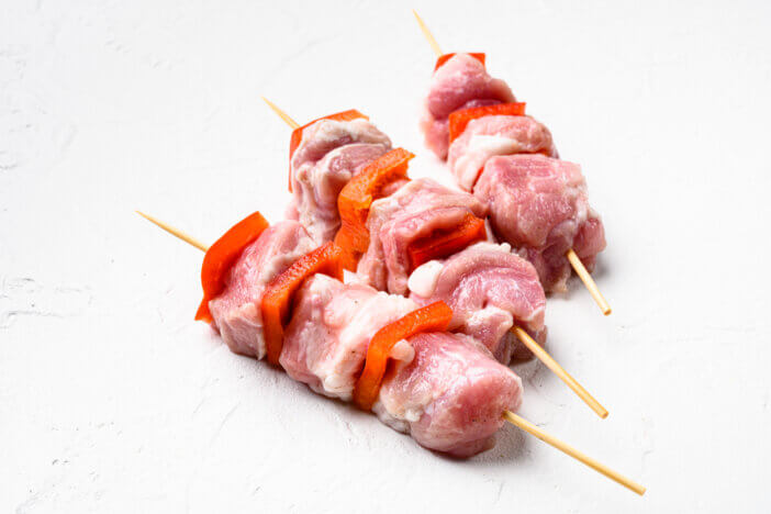 6 Grill Ready Meat Cuts For Grilling Enthusiasts 2 Raw pork shish kebab. BBQ meat with vegetables set, on white stone table background