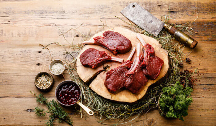 9 Gourmet Meats For Cooking For Home Chefs & Food Bloggers 8 Raw sliced Venison Ribs and meat cleaver on wooden background