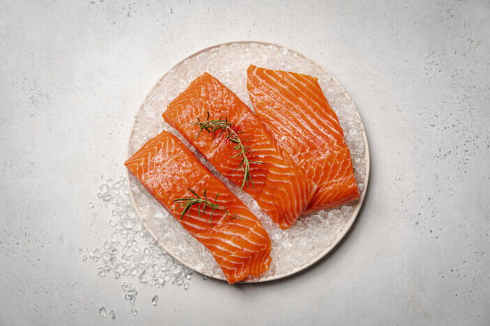 11 Low Fat Meat Options For Health & Fitness Enthusiasts 4 Salmon. Fresh raw salmon fish fillet with ice and herbs on white background, top view